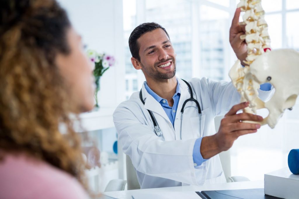 doctor holding spine figure